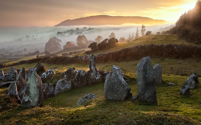 Ancient stones in a misty landscape at sunrise