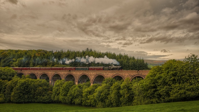 Steam train crossing a stone viaduct in the UK