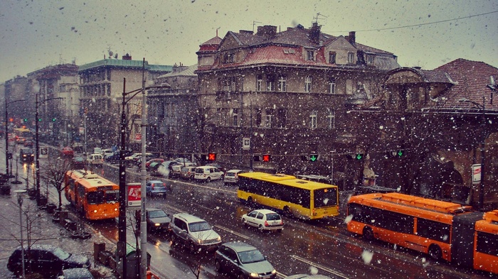 Snowy city street with buses and cars in Belgrade