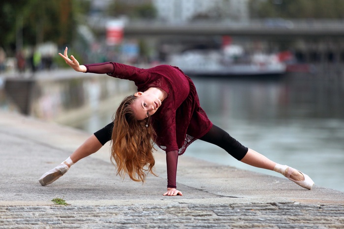 Ballerina with auburn hair dancing outdoors