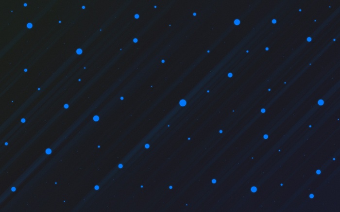 Abstract blue dots on a dark background with light streaks