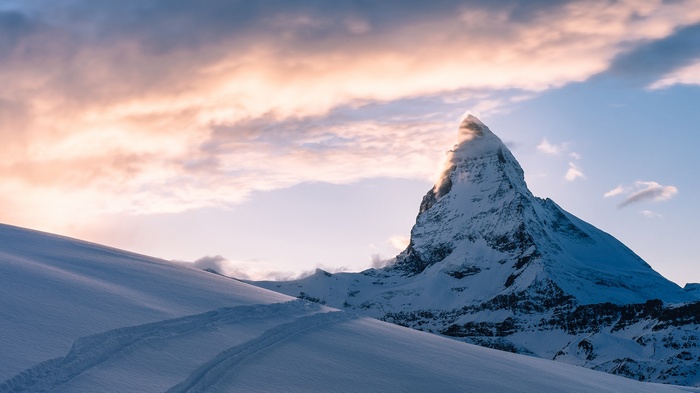 The Matterhorn mountain at sunrise with snow-covered slopes