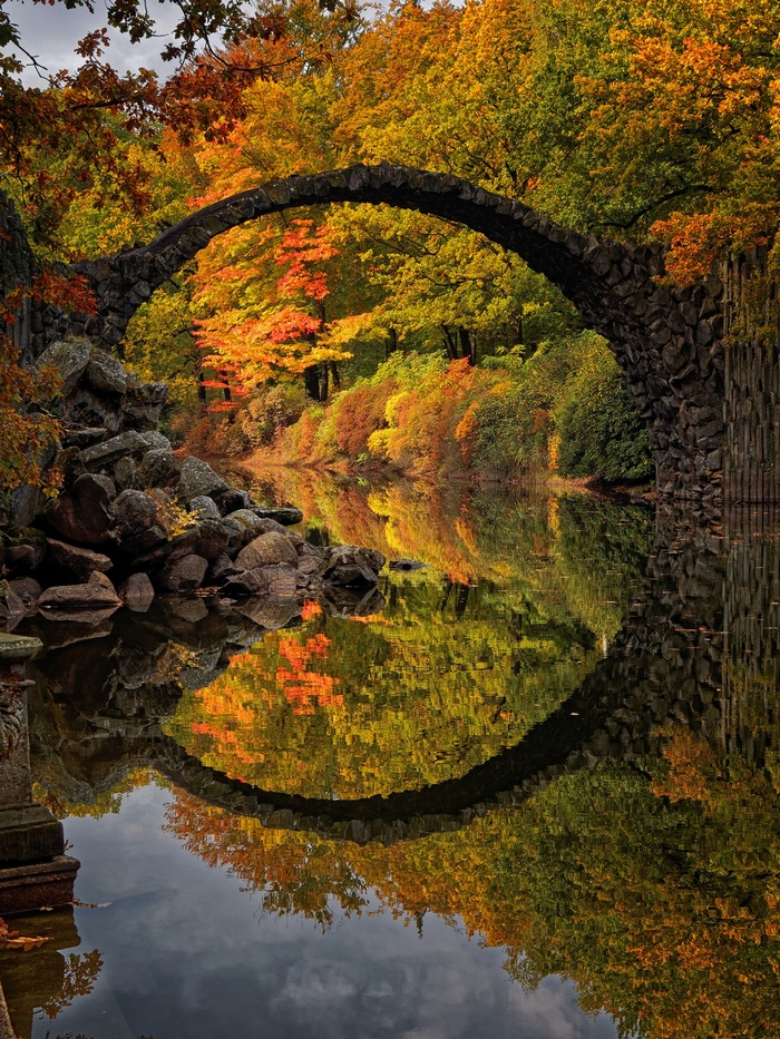 Rakotzbrücke bridge in Germany during fall with reflection