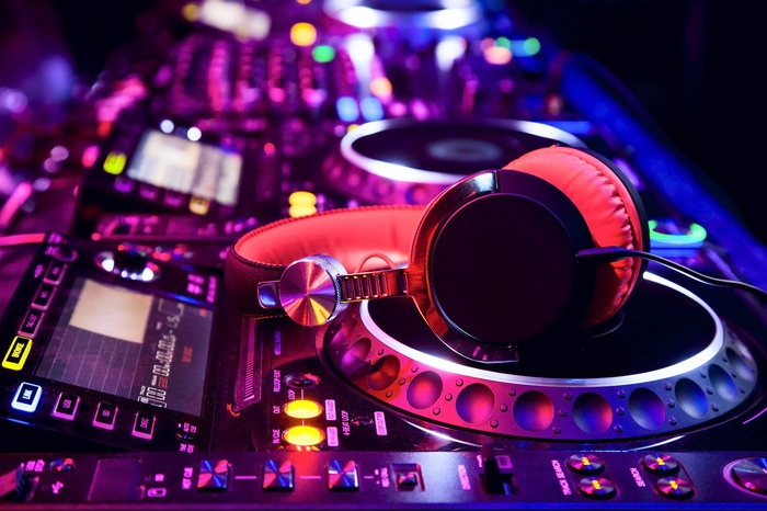 DJ headphones on a music mixer with colorful lights