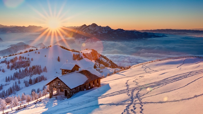 Snowy cabins in the Swiss Alps at sunrise
