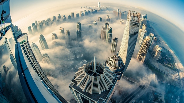 Dubai skyscrapers shrouded in mist, aerial fisheye view