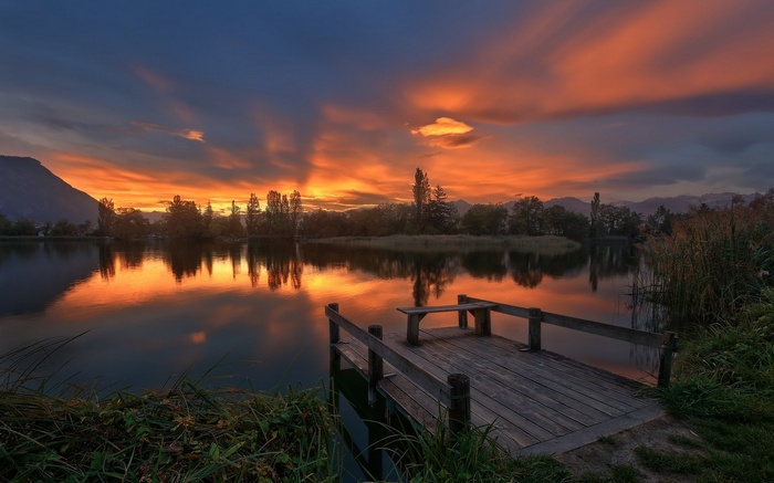 Lake and dock at sunset with mountains in France
