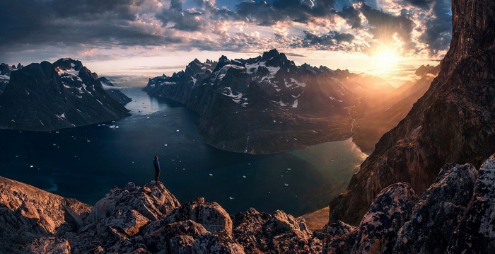Sunset over Greenland mountains with a lone hiker