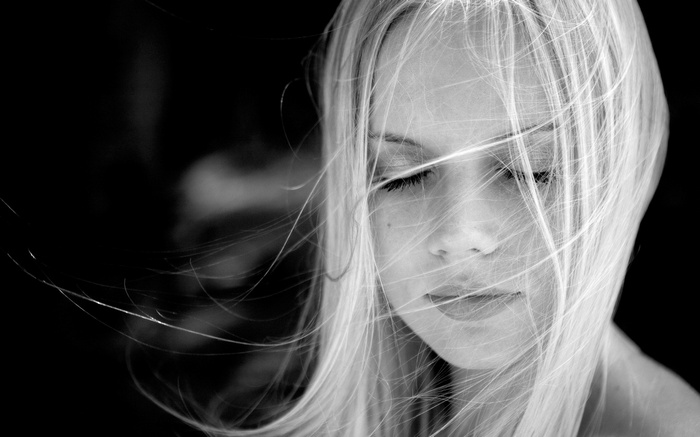 Monochrome portrait of a blonde woman with hair in face