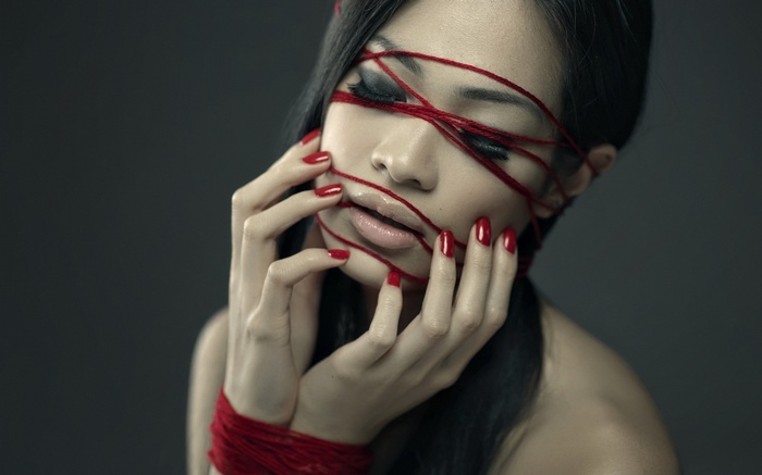 Woman with red string across her face
