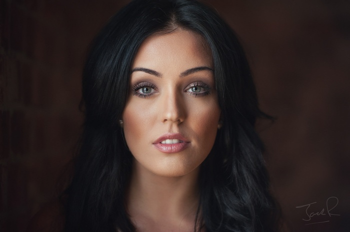 Portrait of a woman with dark hair and green eyes