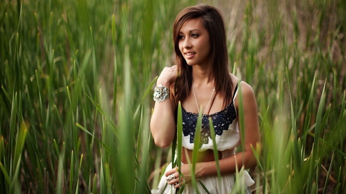 Woman in a dress standing in tall green grass