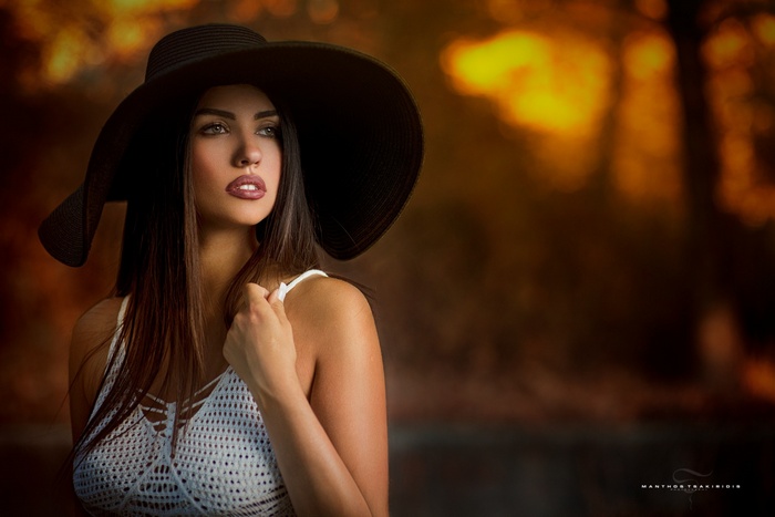 Woman in a wide-brimmed hat and white top