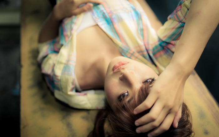 Asian woman with brunette hair lying down