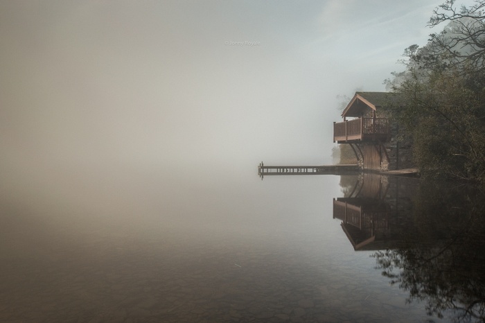 Boathouse on a misty lake in England
