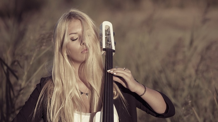 Woman playing a contrabass in a field