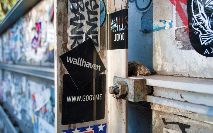 Wallhaven and Gogy.me stickers on a metal pole