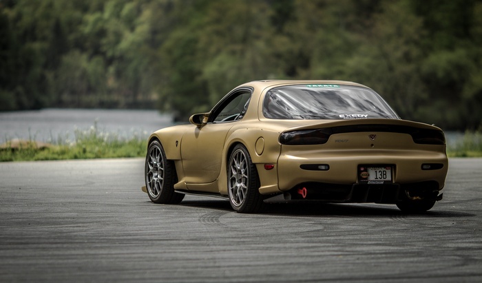 Gold Mazda RX-7 sports car on a track