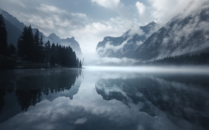 Misty morning lake reflection in the Dolomites