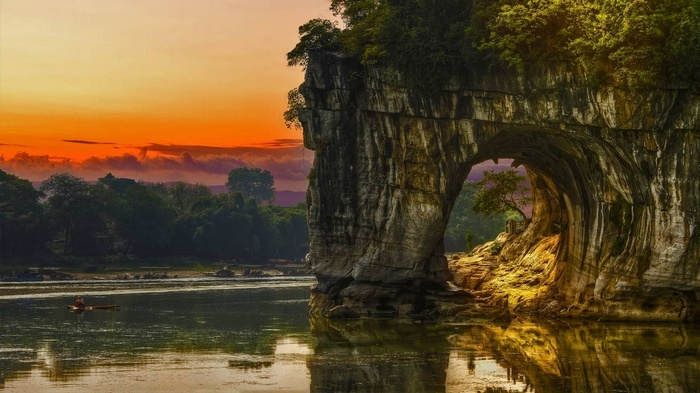 Guilin rock arch over river at sunset