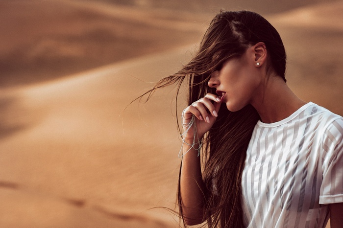 Woman in white see-through clothing in the desert