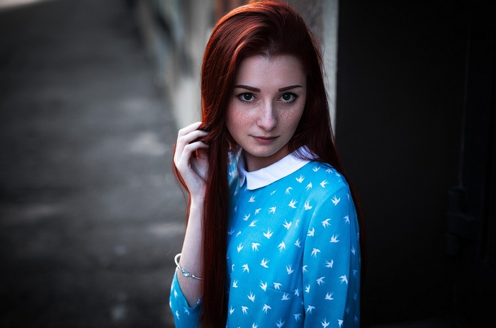 Redhead woman with freckles in a blue dress