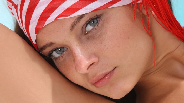 Woman with blue eyes and red and white headscarf