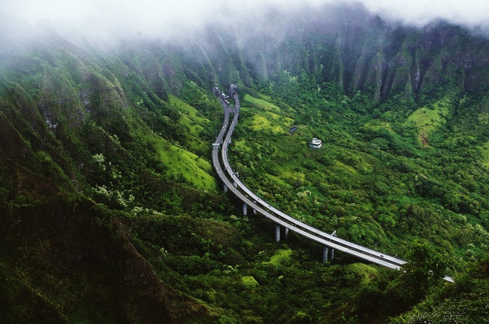 Highway through a misty tropical valley with green mountains