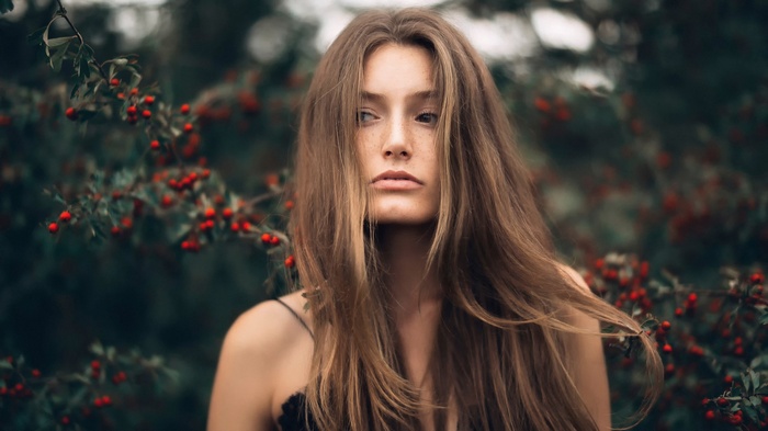 Woman with freckles and long hair in nature