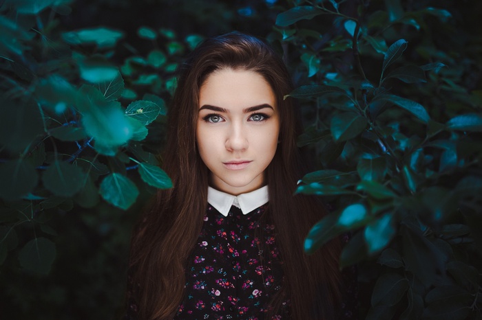 Portrait of a young woman with dark hair and a floral dress