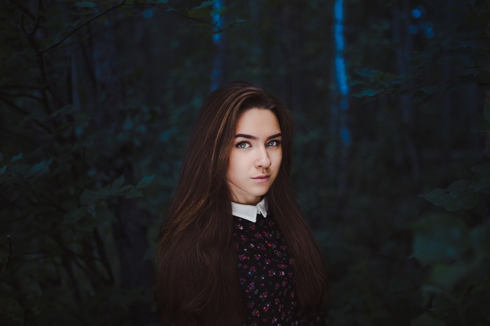 Portrait of a young woman in a dark forest