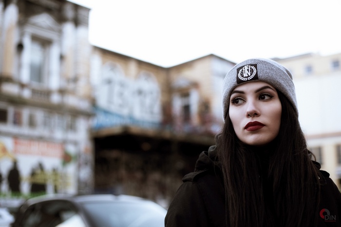 Woman wearing a beanie and lipstick looking away
