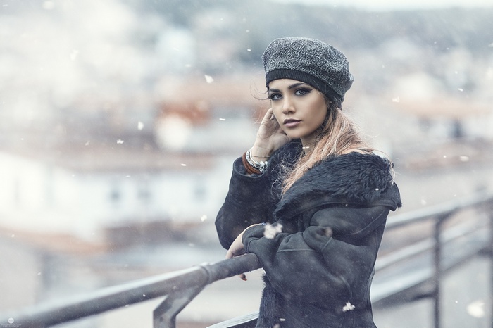 Woman in a fur coat and beret in the snow