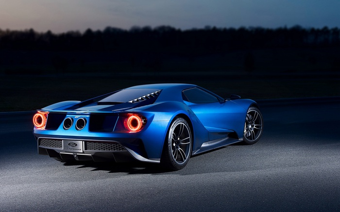 Blue Ford GT car on a race track at dusk