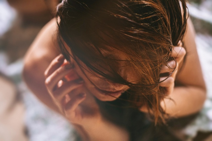 Woman with wet hair touching her face