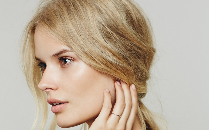 Woman with blonde hair and brown eyes wearing a ring