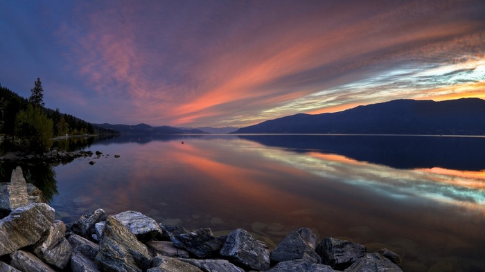 Sunset over a lake in British Columbia with mountains and clouds