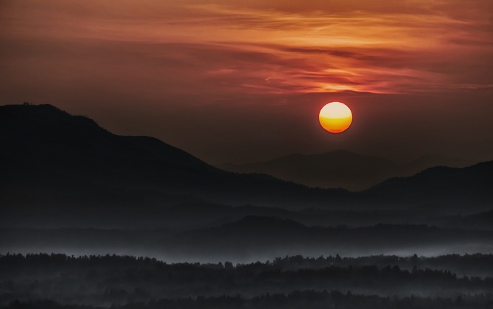 Sunset over misty mountains and forest