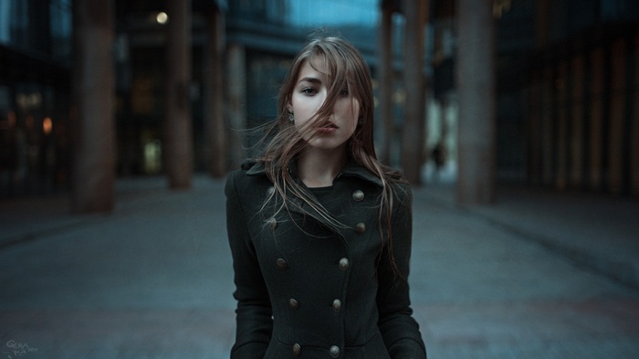 Woman with hair in face wearing a coat