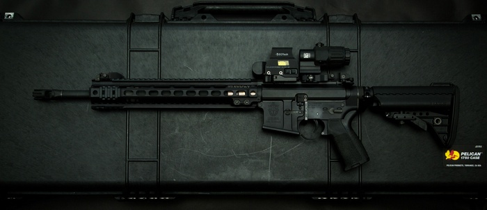 Black AR-15 assault rifle on a Pelican case