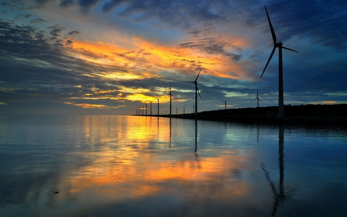 Wind turbines at sunset reflected in the water