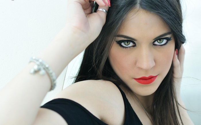 Woman with long dark hair and striking makeup