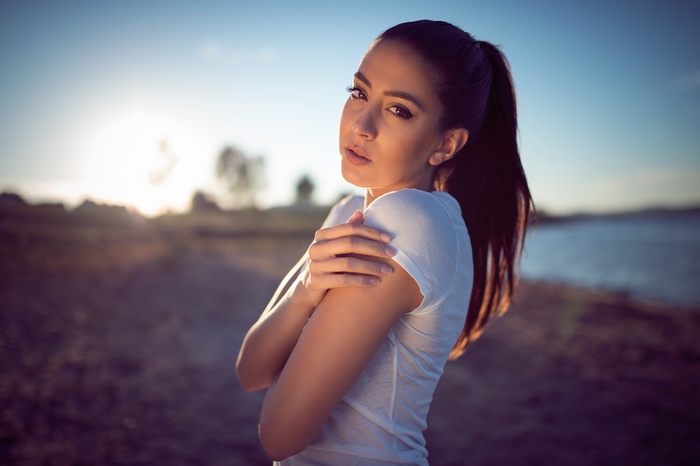 Woman with ponytail on beach at sunset