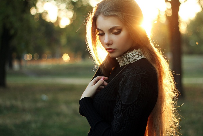 Woman with blonde hair in a black dress at sunset