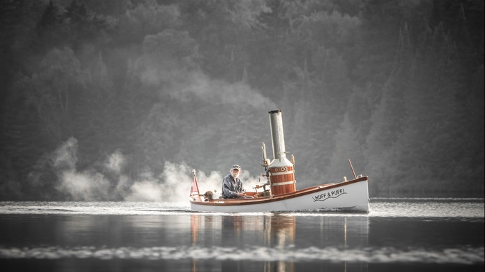 Man on a steamship named Huff & Puff on a misty lake