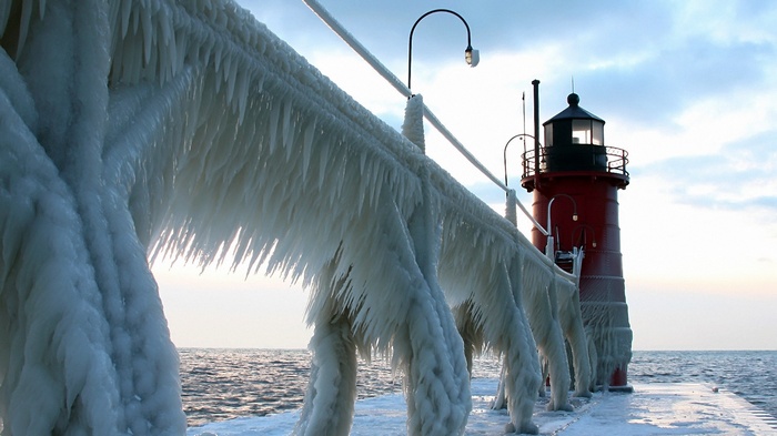 Lighthouse covered in ice on a pier