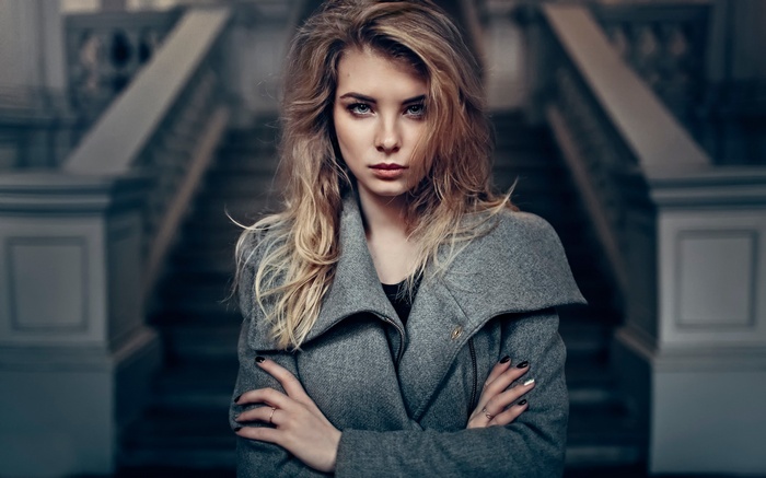 Woman with blonde hair wearing a grey coat