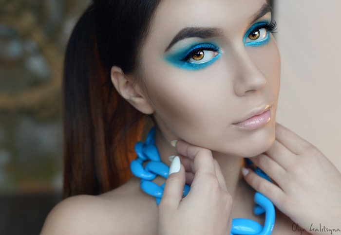 Woman with blue eye makeup and necklace