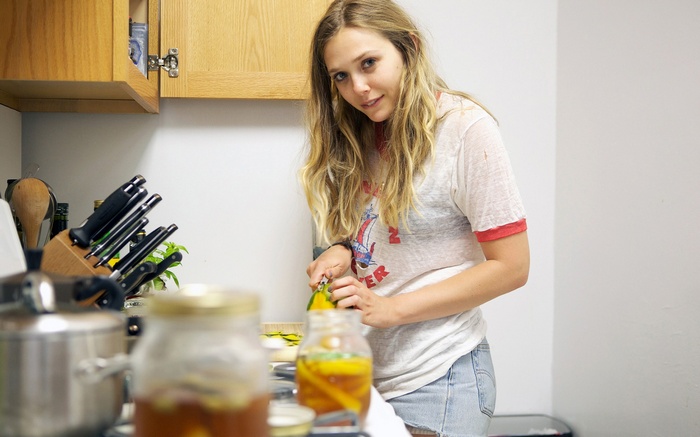 Elizabeth Olsen in a kitchen preparing food