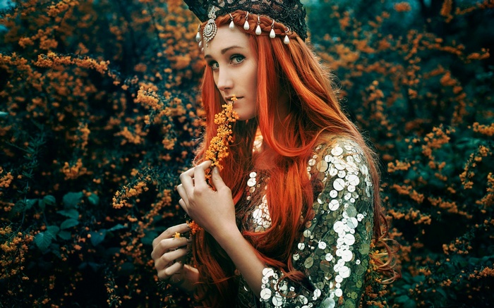 Redhead woman with crown and sequined dress in nature